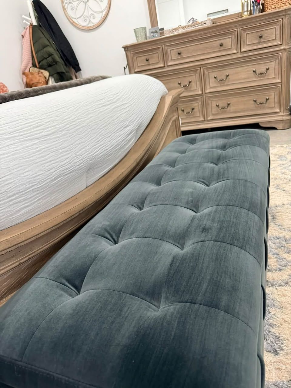 Neatly made bed and tufted bench